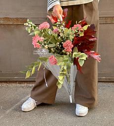 Композиция в зонте из гвоздик и голландской зелени. 